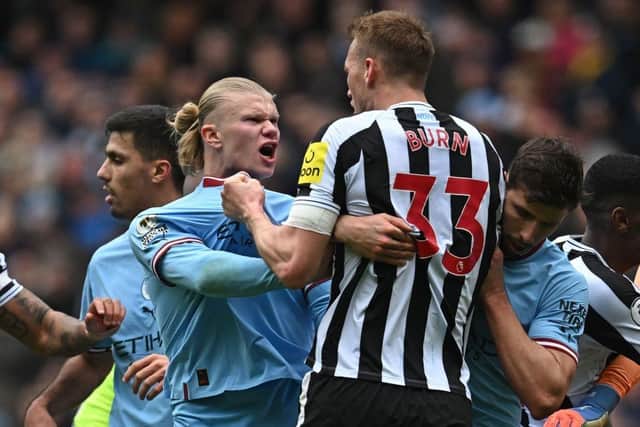 Manchester City striker Erling Haaland clashes with Newcastle United defender Dan Burn.