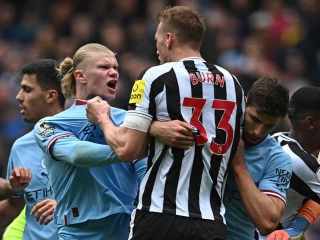 Manchester City striker Erling Haaland clashes with Newcastle United defender Dan Burn.