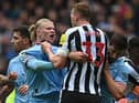 Manchester City striker Erling Haaland clashes with Newcastle United defender Dan Burn.