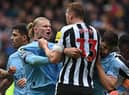 Manchester City striker Erling Haaland clashes with Newcastle United defender Dan Burn.