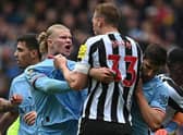 Manchester City striker Erling Haaland clashes with Newcastle United defender Dan Burn.