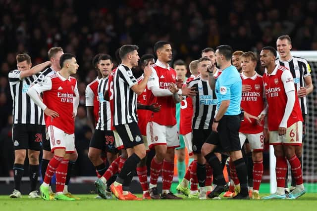 Arsenal players surround the Referee Andy Madley after a late penalty appeal during the Premier League match between Arsenal FC and Newcastle United at Emirates Stadium on January 03, 2023 in London, England. (Photo by Julian Finney/Getty Images)