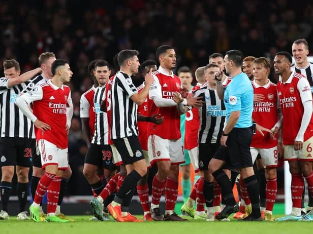 Arsenal players surround the Referee Andy Madley after a late penalty appeal during the Premier League match between Arsenal FC and Newcastle United at Emirates Stadium on January 03, 2023 in London, England. (Photo by Julian Finney/Getty Images)