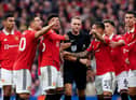 Manchester United players surround referee Craig Pawson at Old Trafford.