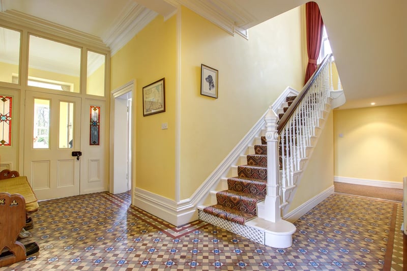 The front door opens onto a generous porch leading into the inviting entrance hall featuring the original tiled floor.