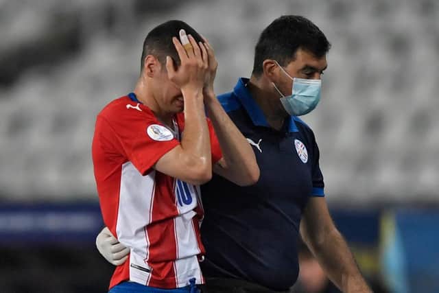 Paraguay's Miguel Almiron leaves the field due to an injury.