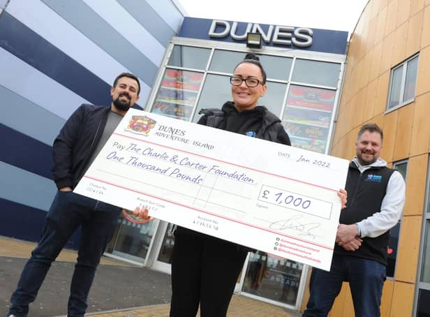 Sarah and Chris Cookson receive a cheque for £1,000 from Dunes Operation Manager Ken Reader, left.