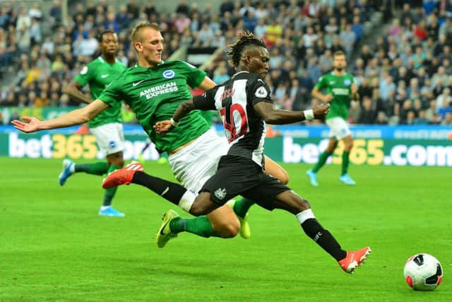 NEWCASTLE UPON TYNE, ENGLAND - SEPTEMBER 21: Christian Atsu of Newcastle is tackled by Dan Burn of Brighton during the Premier League match between Newcastle United and Brighton & Hove Albion at St. James Park on September 21, 2019 in Newcastle upon Tyne, United Kingdom. (Photo by Mark Runnacles/Getty Images)