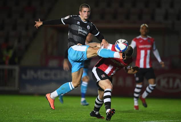 Max Watters of Crawley Town looks to break past Pierce Sweeney of Exeter City during the Sky Bet League Two match between Exeter City and Crawley Town at St James Park.