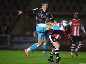 Max Watters of Crawley Town looks to break past Pierce Sweeney of Exeter City during the Sky Bet League Two match between Exeter City and Crawley Town at St James Park.
