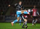 Max Watters of Crawley Town looks to break past Pierce Sweeney of Exeter City during the Sky Bet League Two match between Exeter City and Crawley Town at St James Park.