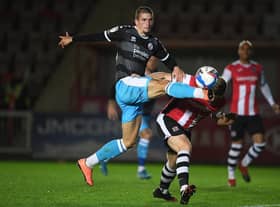 Max Watters of Crawley Town looks to break past Pierce Sweeney of Exeter City during the Sky Bet League Two match between Exeter City and Crawley Town at St James Park.