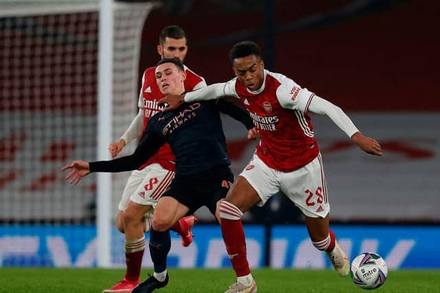 Arsenal's English midfielder Joe Willock (R) pushes back Manchester City's English midfielder Phil Foden (C) during the English League Cup quarter final football match between Arsenal and Manchester City at the Emirates Stadium, in London on December 22, 2020.