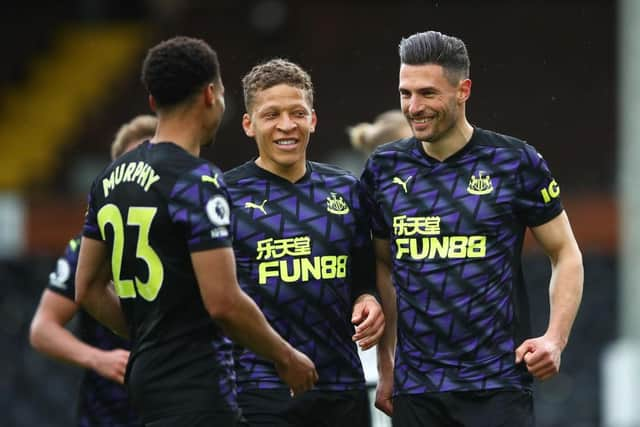 Fabian Schar of Newcastle United celebrates with Dwight Gayle and nu after scoring his sides second goal during the Premier League match between Fulham and Newcastle United at Craven Cottage on May 23, 2021 in London, England.