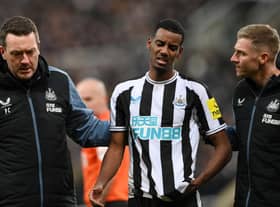 Newcastle United striker Alexander Isak leaves the pitch after being struck on the head with a ball.`
