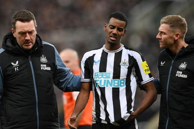 Newcastle United striker Alexander Isak leaves the pitch after being struck on the head with a ball.`