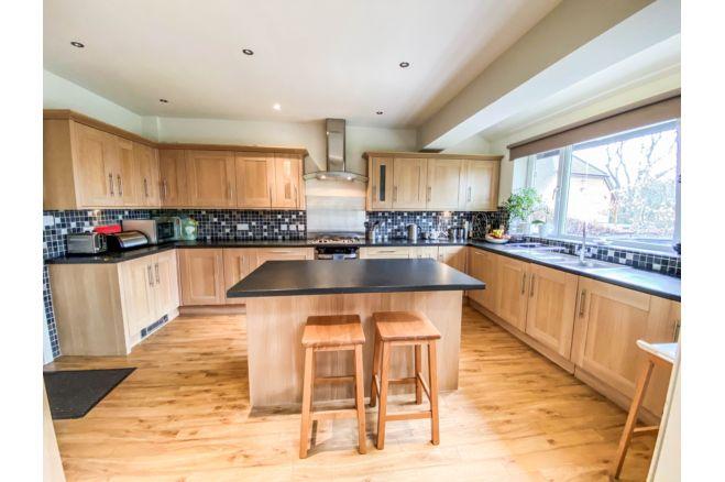 The open plan kitchen diner has a range of modern wall/base units, island and integral appliances. This room also gives access to the double garage.
