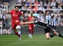 Dan Burn of Newcastle United challenges Mohamed Salah of Liverpool during the Premier League match between Newcastle United and Liverpool at St. James Park on April 30, 2022 in Newcastle upon Tyne, England. (Photo by Stu Forster/Getty Images)