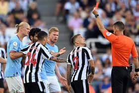 NEWCASTLE UPON TYNE, ENGLAND - AUGUST 21: Kieran Trippier of Newcastle United is shown a red card by referee Jarred Gillett which is later overturned to a yellow card  during the Premier League match between Newcastle United and Manchester City at St. James Park on August 21, 2022 in Newcastle upon Tyne, England. (Photo by Stu Forster/Getty Images)