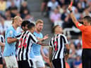 Kieran Trippier of Newcastle United is shown a red card by referee Jarred Gillett which is later overturned to a yellow card  during the Premier League match between Newcastle United and Manchester City at St. James Park on August 21, 2022 in Newcastle upon Tyne, England. (Photo by Stu Forster/Getty Images)