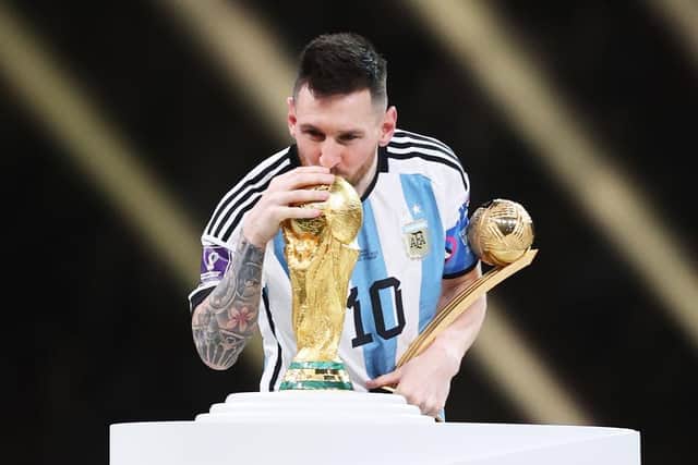 Lionel Messi of Argentina kisses the FIFA World Cup Qatar 2022 Winners' Trophy while holding the adidas Golden Boot award after the FIFA World Cup Qatar 2022 Final match between Argentina and France at Lusail Stadium on December 18, 2022 in Lusail City, Qatar. (Photo by Julian Finney/Getty Images)