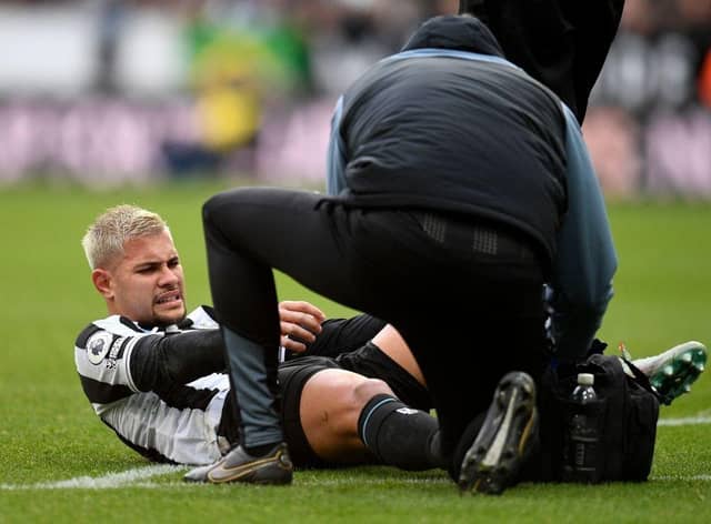 Newcastle United midfielder Bruno Guimaraes receives medical treatment.