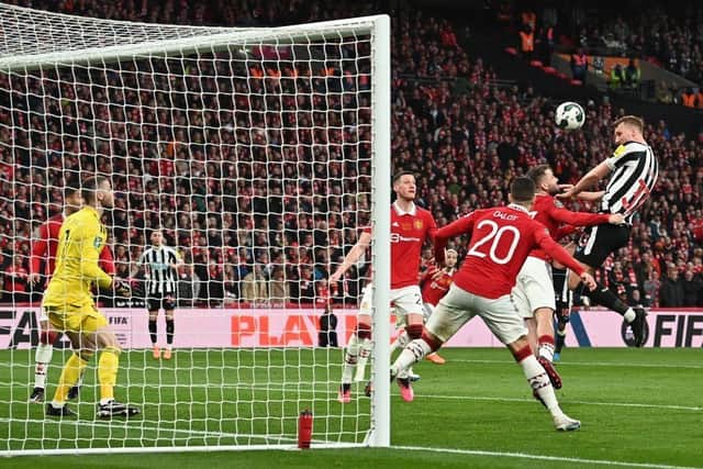 Newcastle United's English defender Dan Burn (R) headers at goal but fails to score during the English League Cup final football match between Manchester United and Newcastle United at Wembley Stadium, north-west London on February 26, 2023. (Photo by GLYN KIRK/AFP via Getty Images)