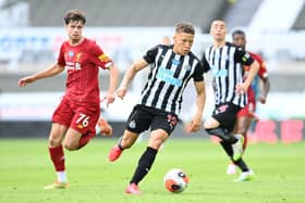 Dwight Gayle of Newcastle United gets away from Neco Williams of Liverpool during the Premier League match between Newcastle United and Liverpool FC at St. James Park on July 26, 2020 in Newcastle upon Tyne, England.