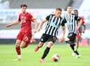 Dwight Gayle of Newcastle United gets away from Neco Williams of Liverpool during the Premier League match between Newcastle United and Liverpool FC at St. James Park on July 26, 2020 in Newcastle upon Tyne, England.