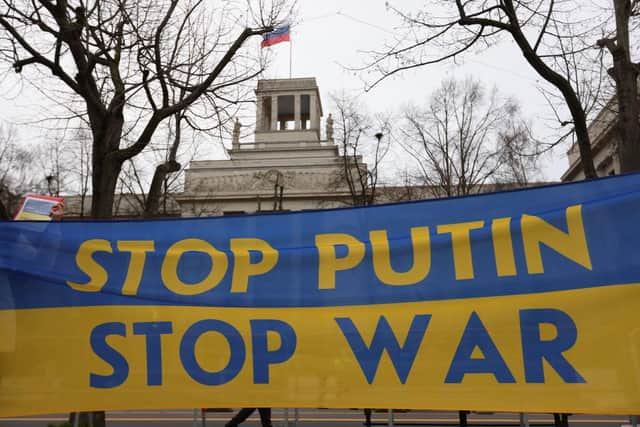 Protesters hold a banner reading in front of the Russian Embassy in Berlin. Picture: Omer Messinger/Getty Images.