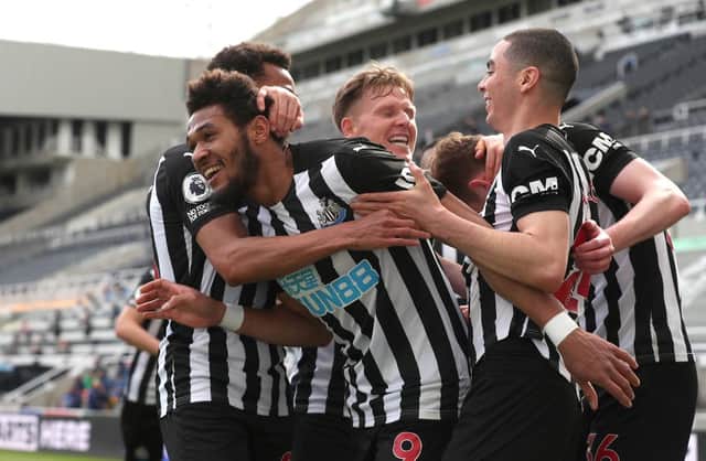 Joelinton of Newcastle United celebrates with team mates after scoring their side's first goal during the Premier League match between Newcastle United and Tottenham Hotspur at St. James Park on April 04, 2021 in Newcastle upon Tyne, England.