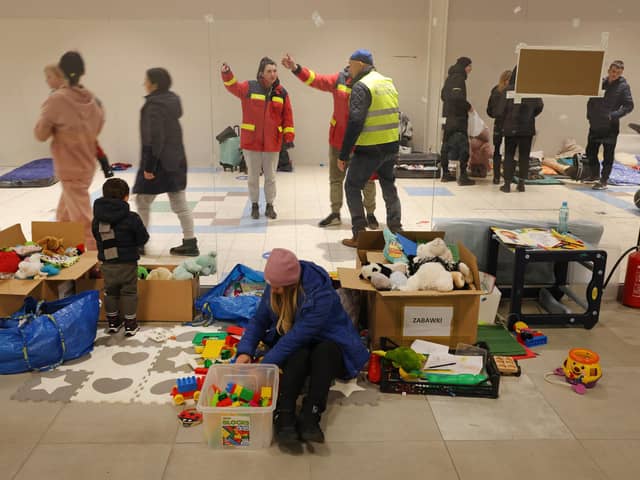 PRZEMYSL, POLAND - MARCH 03: A mother and child who have fled from war in Ukraine sit among donated toys at a temporary shelter set up in a former shopping center on March 03, 2022 in Przemysl, Poland. Most arrivees spend only a short time at the shelter before being picked up by relatives among the Ukrainian diaspora or traveling onward by bus or train. Over one million people have left Ukraine since Russian launched its military invasion one week ago. (Photo by Sean Gallup/Getty Images)