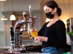 Karine Makarova pulls a pint of Stella Artois behind the bar at the Red Lion & Sun in Highgate, London as outdoor hospitality reopens