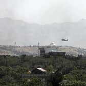 A. US Black Hawk military helicopter flies over the city of Kabul, Afghanistan, Sunday, Aug. 15, 2021. Taliban fighters entered the outskirts of the Afghan capital on Sunday and said they were awaiting a 'peaceful transfer' of the city after promising not to take it by force, but amid the uncertainty panicked workers fled government offices and helicopters landed at the US Embassy. (AP Photo/Rahmat Gul)