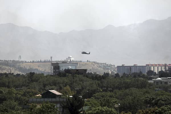 A. US Black Hawk military helicopter flies over the city of Kabul, Afghanistan, Sunday, Aug. 15, 2021. Taliban fighters entered the outskirts of the Afghan capital on Sunday and said they were awaiting a 'peaceful transfer' of the city after promising not to take it by force, but amid the uncertainty panicked workers fled government offices and helicopters landed at the US Embassy. (AP Photo/Rahmat Gul)