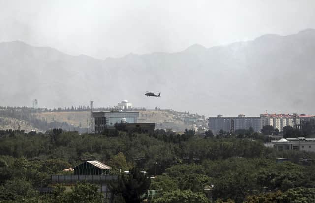 A. US Black Hawk military helicopter flies over the city of Kabul, Afghanistan, Sunday, Aug. 15, 2021. Taliban fighters entered the outskirts of the Afghan capital on Sunday and said they were awaiting a 'peaceful transfer' of the city after promising not to take it by force, but amid the uncertainty panicked workers fled government offices and helicopters landed at the US Embassy. (AP Photo/Rahmat Gul)