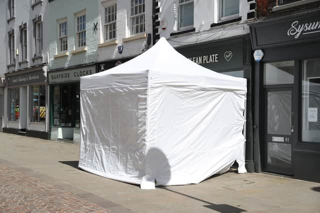 A police tent outside The Clean Plate cafe in Southgate Street, Gloucester.