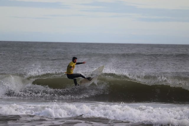 Surfer Jesse Davies riding waves at Sandhaven Beach