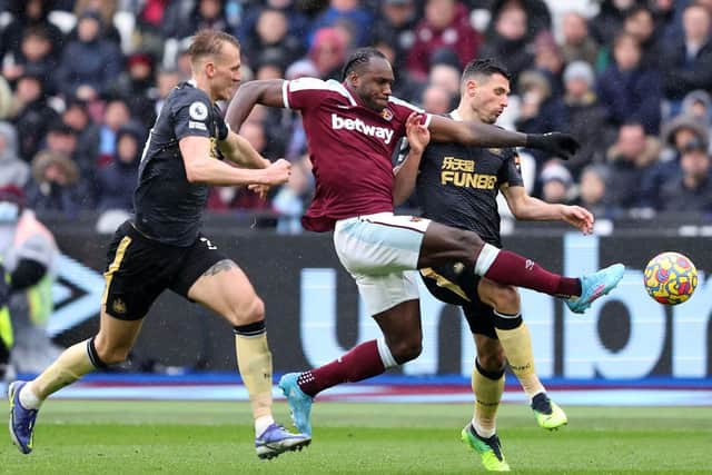 Michail Antonio of West Ham United is challenged by Emil Krafth and Fabian Schaer of Newcastle United during the Premier League match between West Ham United and Newcastle United at London Stadium on February 19, 2022 in London, England. (Photo by Warren Little/Getty Images)