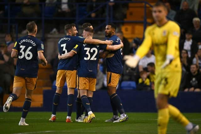 Newcastle United's English defender Jamaal Lascelles (2nd-R) celebrates with his teammates after scoring a goal during the English League Cup second round football match between Tranmere Rovers and Newcastle United at Prenton Park Stadium in Birkenhead, north of England, on August 24, 2022. - - RESTRICTED TO EDITORIAL USE. No use with unauthorized audio, video, data, fixture lists, club/league logos or 'live' services. Online in-match use limited to 120 images. An additional 40 images may be used in extra time. No video emulation. Social media in-match use limited to 120 images. An additional 40 images may be used in extra time. No use in betting publications, games or single club/league/player publications. (Photo by Paul ELLIS / AFP) / RESTRICTED TO EDITORIAL USE. No use with unauthorized audio, video, data, fixture lists, club/league logos or 'live' services. Online in-match use limited to 120 images. An additional 40 images may be used in extra time. No video emulation. Social media in-match use limited to 120 images. An additional 40 images may be used in extra time. No use in betting publications, games or single club/league/player publications. / RESTRICTED TO EDITORIAL USE. No use with unauthorized audio, video, data, fixture lists, club/league logos or 'live' services. Online in-match use limited to 120 images. An additional 40 images may be used in extra time. No video emulation. Social media in-match use limited to 120 images. An additional 40 images may be used in extra time. No use in betting publications, games or single club/league/player publications. (Photo by PAUL ELLIS/AFP via Getty Images)