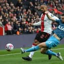 Theo Walcott of Southampton is tackled by Ben Davies of Tottenham Hotspur during the Premier League match between Southampton FC and Tottenham Hotspur at Friends Provident St. Mary's Stadium on March 18, 2023 in Southampton, England. (Photo by Mike Hewitt/Getty Images)