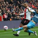 Theo Walcott of Southampton is tackled by Ben Davies of Tottenham Hotspur during the Premier League match between Southampton FC and Tottenham Hotspur at Friends Provident St. Mary's Stadium on March 18, 2023 in Southampton, England. (Photo by Mike Hewitt/Getty Images)