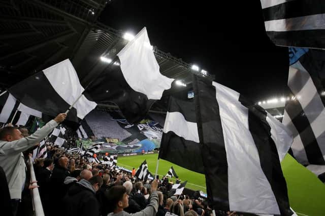 Newcastle United fans wave flags. (Photo by George Wood/Getty Images).