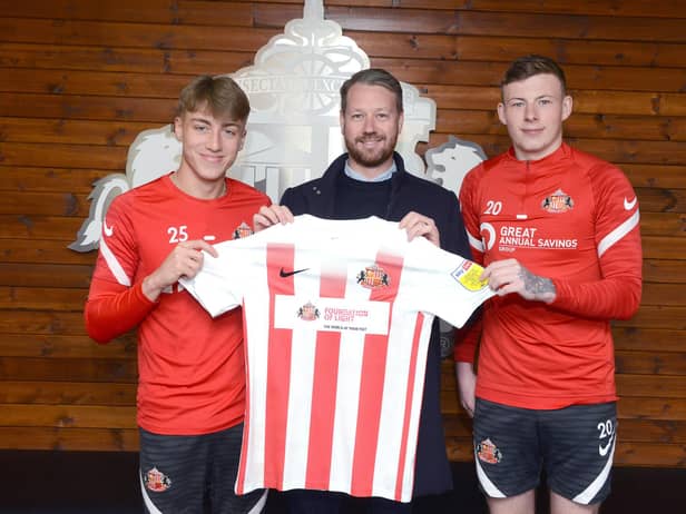 SAFC players Jack Clarke and Anthony Patterson holding the special edition Foundation of Light shirt alongside Great Annual Savings Group’s operations director Craig Shields.