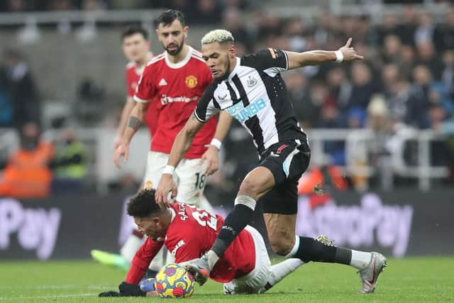 Joelinton of Newcastle United runs with the ball past Jadon Sancho of Manchester United during the Premier League match between Newcastle United and Manchester United at St James' Park on December 27, 2021 in Newcastle upon Tyne, England. (Photo by Ian MacNicol/Getty Images)