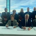 Mr Gove signs the deal, flanked by local leaders including Coun Tracy Dixon (back row, second left), Coun Graeme Miller (back row, fifth left) and Coun Glen Sanderson (front right)