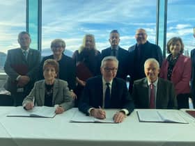 Mr Gove signs the deal, flanked by local leaders including Coun Tracy Dixon (back row, second left), Coun Graeme Miller (back row, fifth left) and Coun Glen Sanderson (front right)
