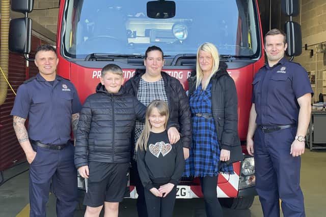 Olivia with her family and members of the fire service.