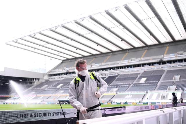 Staff disinfects the areas around the pitch during the Premier League match between Newcastle United and Sheffield United at St James's Park.