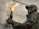 A local resident prepares to use a Molotov cocktail against a wall during an all-Ukrainian training campaign "Don't panic! Get ready!" close to Kyiv, Ukraine, Sunday, Feb. 6, 2022. (AP Photo/Efrem Lukatsky)